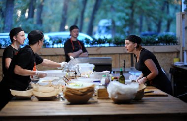 Garson ve garson bir restoranın mutfak masasında fast food hazırlarken iletişim kurar.