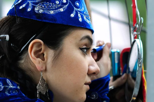 Crimean tartar girl in a native dress putting on makeup before celebrating of Hidirellez, festival of arrival of spring — Stock Photo, Image