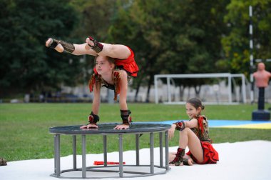 Bir grup küçük kız akrobat bir futbol sahasında akrobatik egzersiz yapıyor. 20 Haziran 2019 Kiev, Ukrayna
