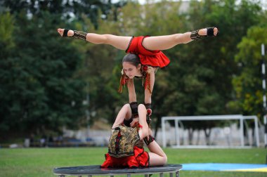 Bir grup küçük kız akrobat bir futbol sahasında akrobatik egzersiz yapıyor. 20 Haziran 2019 Kiev, Ukrayna