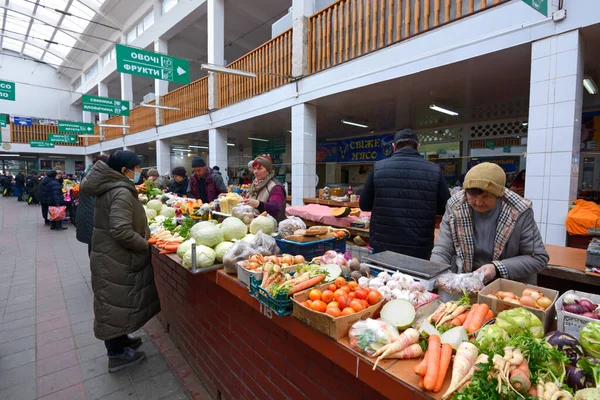 Woman buying vegetables, seller standing behind counter. Central Uzhgorod food market — стокове фото