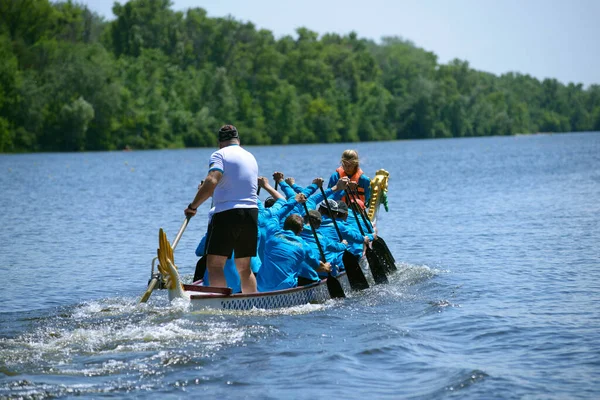 Kürekçiler nehirde ejderha teknesiyle kürek çekiyor. Amatörler arasında Kiev Oblast şampiyonası. 25 Mayıs 2019. Kiev, Ukrayna
