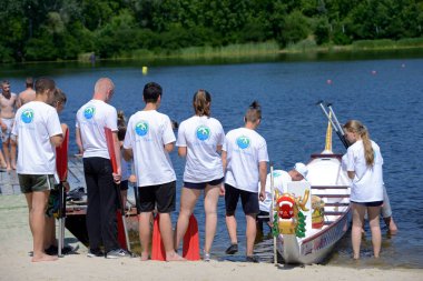Kürekçiler bir tekneye binip yarışı başlatmak için rıhtımdan ayrılıyorlar. 25 Mayıs 2019. Kiev, Ukrayna