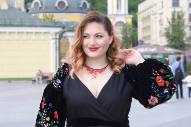 Ukrayna işlemeli tişörtlü gülümseyen kadın sokakta dikiliyor. Nakışlı tişört gününü kutluyoruz. 16 Mayıs 2019. Kiev, Ukrayna