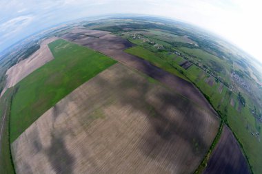 Bir balon sepetinden çıkan tarlaları ve köyleri olan bir dünya manzarası.