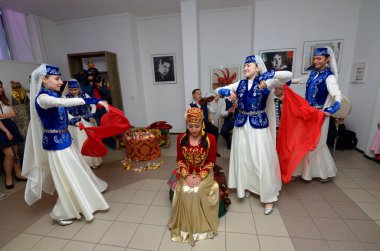 Kırım Tatar geleneksel nikahı: nedimeler bir gelini damat ile buluşmaya hazırlarken kırmızı örtüsünü örterler. Kırım Tatar Kültürü Günleri. 27 Şubat 2019. Kiev, Ukrayna