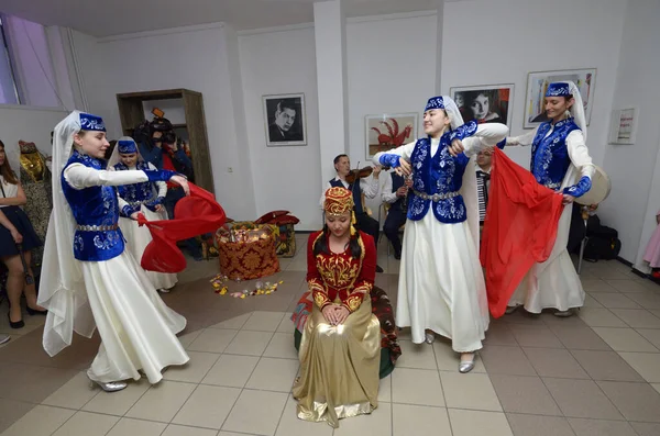 Kırım Tatar geleneksel nikahı: nedimeler bir gelini damat ile buluşmaya hazırlarken kırmızı örtüsünü örterler. Kırım Tatar Kültürü Günleri. 27 Şubat 2019. Kiev, Ukrayna