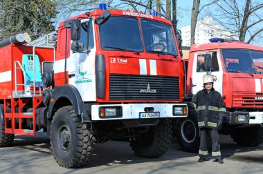 İtfaiyeciler eğitimden önce itfaiye arabalarının yanında dururlar. 5 Nisan 2019. Sviatoshyn İlçesi Ormanı, Kievskaya oblast, Ukrayna