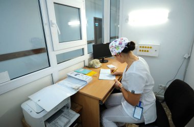 Hastanede görevdeyim. Hemşire hemşire odasında oturuyor ve gazeteye yazıyor. 12 Ocak 2019. Kiev Bölge Kliniği 1. Kiev, Ukrayna