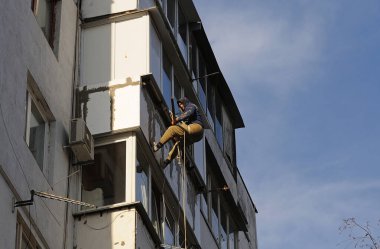 Yüksek irtifa kurucusu bir apartmanın balkonuna televizyon anteni yerleştiriyor. 23 Kasım 2012. Kyiv, Ukrayna