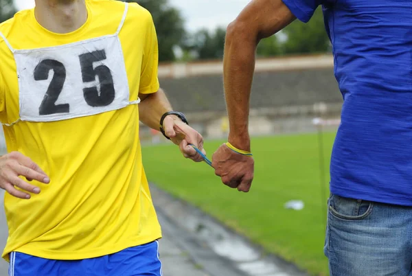 Way of leading blind runner: hand of disabled athlete, on a left, holding hand of healthy one by rope.