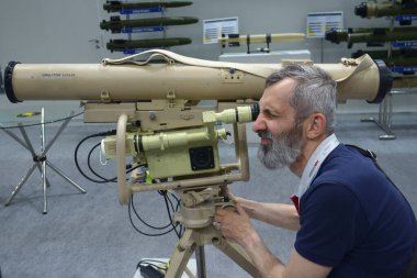 Adam tanksavar füze fırlatma sistemi Corsar 'ın simülatörünün gözüne bakıyor. Silah ve Güvenlik Sergisi. 15 Haziran 2021. Kyiv Ukrayna
