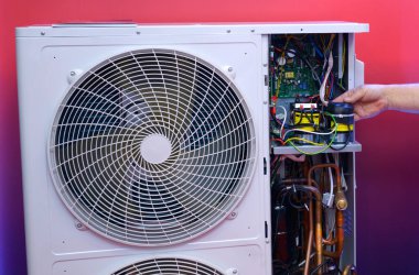 Modern klimanın elektronik kontrol ünitesini tutan adam söküldü..