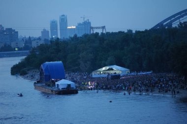 Kalabalık nehir sahilinde toplandı. Sahne suyun üzerinde, gece görüş alanında. 5 Eylül 2019. Kyiv, Truhanov Adası, Ukrayna