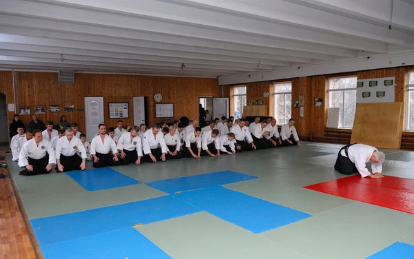 畳の上で練習者のグループは スポーツクラブで訓練する前に合気道インストラクターの話を聞く 2018年2月6日 ウクライナのキエフ — ストック写真