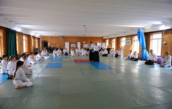 Grupp Praktikanter Kimono Knäböjer Tatami Lyssnar Aikidoinstruktören Innan Tränar Idrottsklubb — Stockfoto