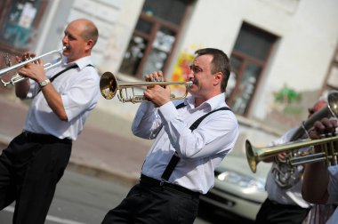 Musicians from a brass orchestra walking down the street playing trumpets. Celebratinainian national g the Day of Dnipro river. July 7, 2019. Kyiv, Ukraine