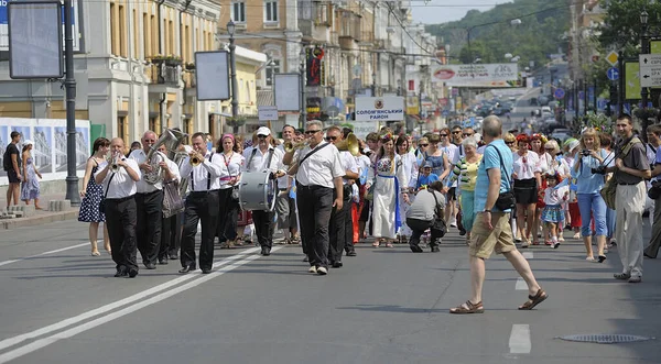 Bando orkestrasından müzisyenler sokakta müzik çalarken, Ukrayna ulusal nakışlı gömleklerle peşlerinden gelen bir kalabalık. Dinyeper Nehri Günü 'nü kutluyoruz. 7 Temmuz 2019
