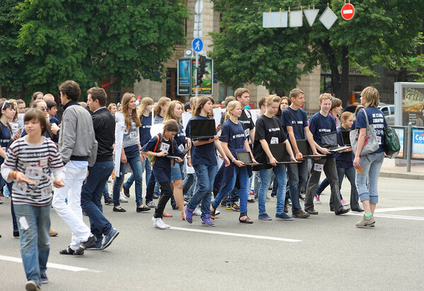 Группа подростков марширует по улице с ноутбуками в руках. Флешмоб не сдаваться. 19 мая 2019 года. Киев, Украина