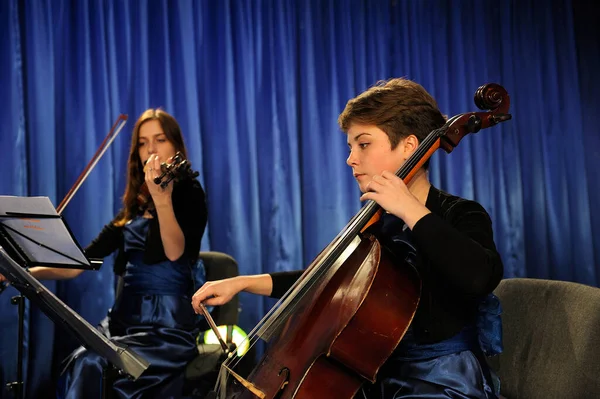 Young pretty women violinist and cellist playing music during concert. November 12, 2013. Kyiv ,Ukraine