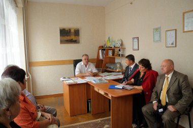 Man principal holding a meeting in his office, teachers listening to, typical Ukrainian secondary school. August 13, 2019. Chernigiv, Ukraine