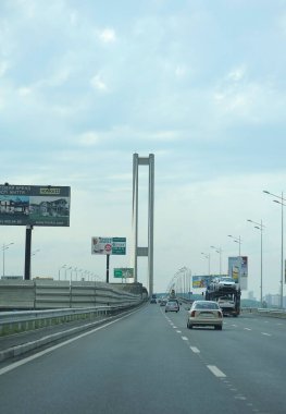 Cars driving on the South bridge road, struts, bracing, lamps, billboards. Evening light. September 18, 2019 Kyiv Ukraine