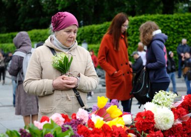 Zafer Günü 'nü kutlamak için insanlar Zafer Parkı' ndaki Sonsuz Alev 'e çiçek koyuyor. 9 Mayıs 2019. Kyiv, Ukrayna