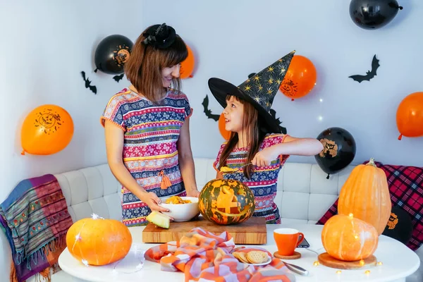 Moeder en dochter hebben plezier schoonmaken van binnenkant van pompoen naar jack o lantaarn voor Halloween samen te maken — Stockfoto