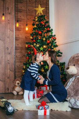 Anne ve kızı Noel 'i ve Noel ağacının yakınındaki yeni yılı kutluyor.