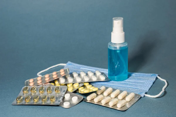 Pandemická prevence. Lékařské masky antiseptický sprej teblets vitamíny na modrém pozadí Royalty Free Stock Fotografie