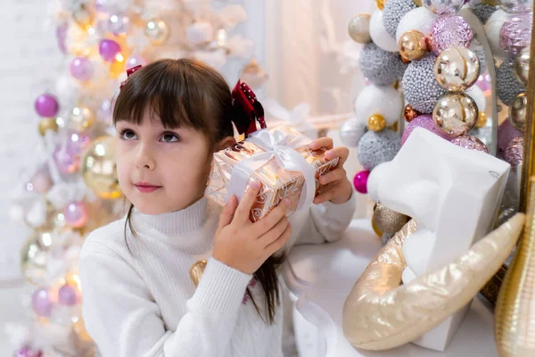 Küçük bir kız Noel Baba 'dan bir Noel hediyesi açar. Noel Masalı. Elinde hediye kutusu olan mutlu çocuk. — Stok fotoğraf
