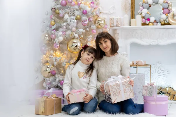 Mutlu anne ve çocuklu Noel ağacı ve hediye kutuları yanında oturuyor — Stok fotoğraf
