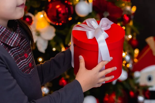 Noel dekorasyonunda hediye kutusu tutan küçük bir çocuk. Kapatın. Yeni yıl dekorasyonu — Stok fotoğraf