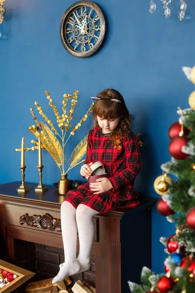 Ciddi kız çocuğu yılbaşı hediyesi kutusunu açıyor. Noel süslemesi