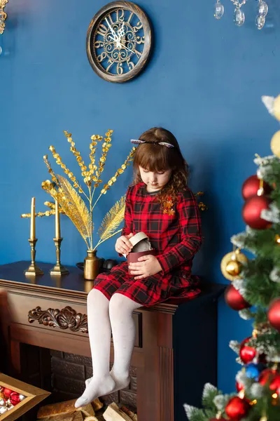 Vážná holčička otevírá vánoční novoroční dárkovou krabici. Vánoční ozdoba Stock Obrázky