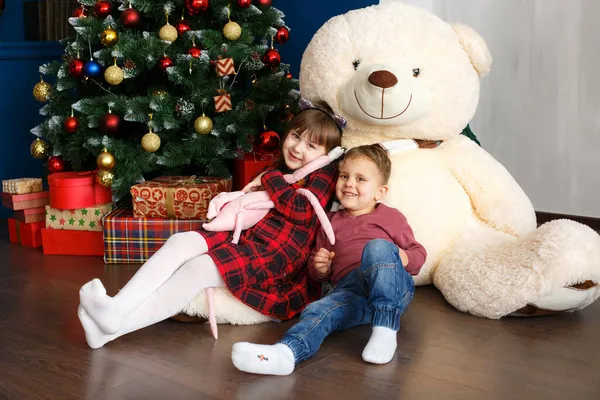 Rodina na Vánoce s medvídkem pod stromečkem. Vánoční dárkové krabice a dekorace Stock Fotografie