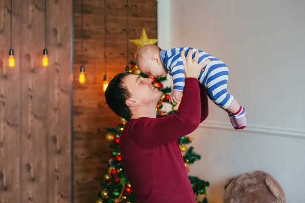 Mutlu baba ve küçük oğlu Noel ağacının yanında ellerinde. Arkadaş canlısı aile kavramı