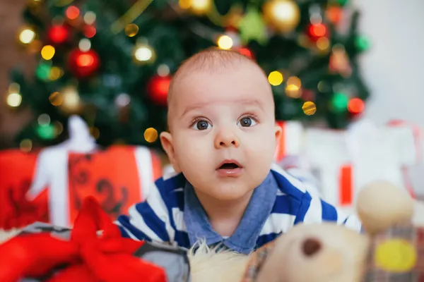 Noel süsü verilmiş şirin küçük bir çocuk. Beyaz mavi gömlekli çocuk beyaz halıda yatıyor. — Stok fotoğraf