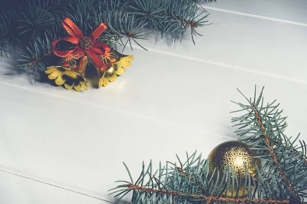 Fondo de madera blanco navideño con ramas de pino bolas doradas, conos, campanas. Copiar espacio — Foto de Stock
