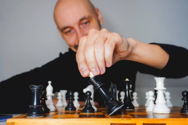 Güvertede satranç oynayan kel adam. Strateji ve rekabet konsepti. Seçici odak