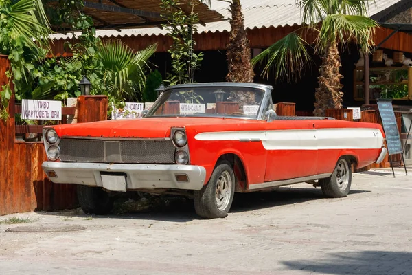 Eski klasik kırmızı araba Cabriolet caddede. Dönüştürülebilir otomobil konsepti