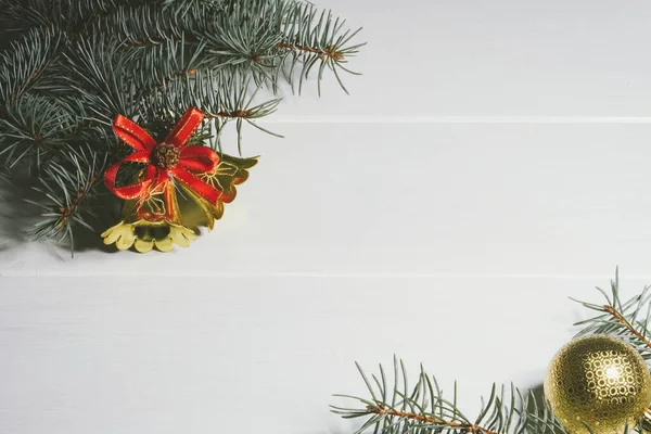 Fondo de madera blanco navideño con ramas de pino bolas doradas, conos, campanas. Copiar espacio — Foto de Stock