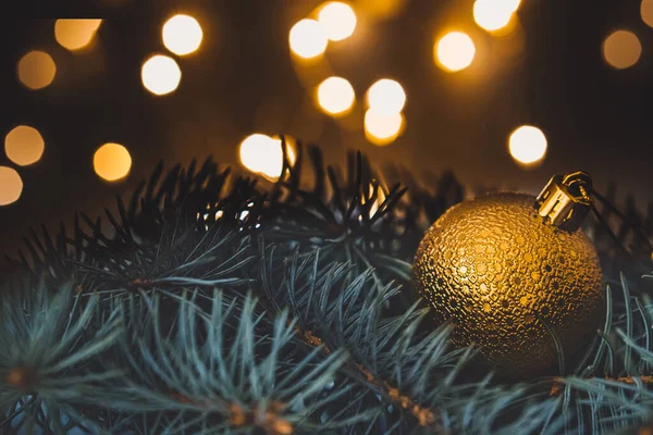 Fondo de Navidad. Bola de Navidad en ramas de pino con luces borrosas en el fondo — Foto de Stock