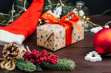 Kırmızı fiyonklu ve ışıklandırılmış ağaç dallı Noel hediyesi kutusu. Yeni yıl konsepti. Seçici odak