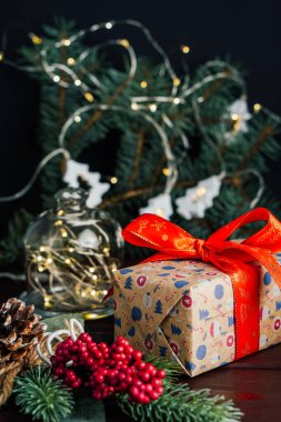 Kırmızı fiyonklu ve ışıklandırılmış ağaç dallı Noel hediyesi kutusu. Yeni yıl konsepti. Seçici odak