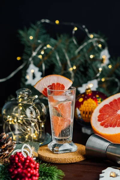 Bebida de cóctel de Navidad con pomelo en vaso de chupito en la decoración de Navidad. Enfoque selectivo — Foto de Stock