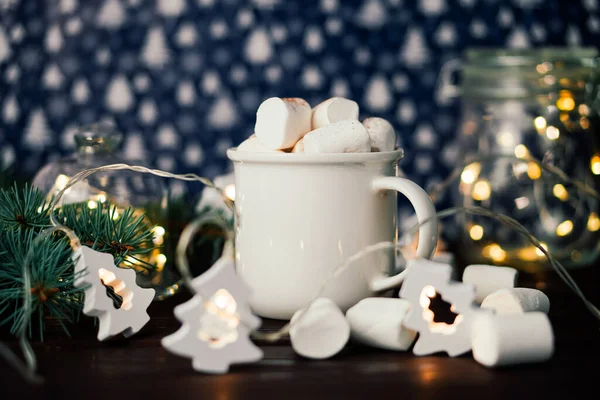 Bebida de Navidad chocolate caliente con malvaviscos en la decoración iluminada festiva. Enfoque selectivo — Foto de Stock