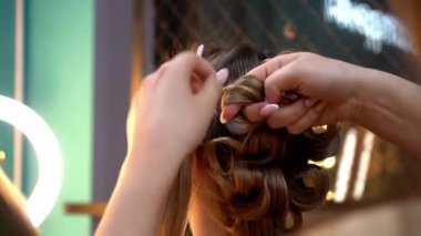 Kuaför, makyöz, kuaför ve kuaför. Güzellik salonunda genç bir kadına makyaj yapıyor.