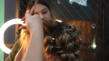 Kuaför, makyöz, kuaför ve kuaför. Güzellik salonunda genç bir kadına makyaj yapıyor.