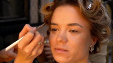 Kaş makyajı mı? Profesyonel makyöz fırçayla genç bir kadının kaşlarını boyuyor. Kapat..
